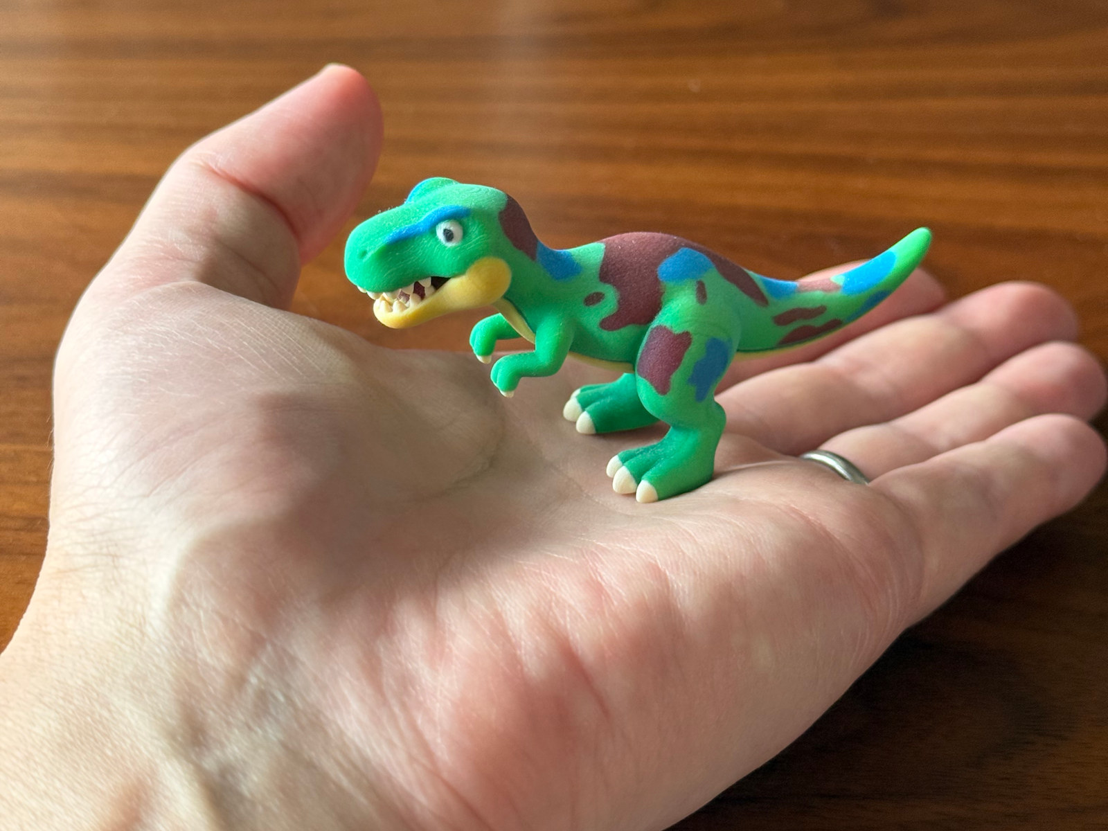 実物サンプル：恐竜のフィギュアを手のひらにのせて大きさを比べた写真